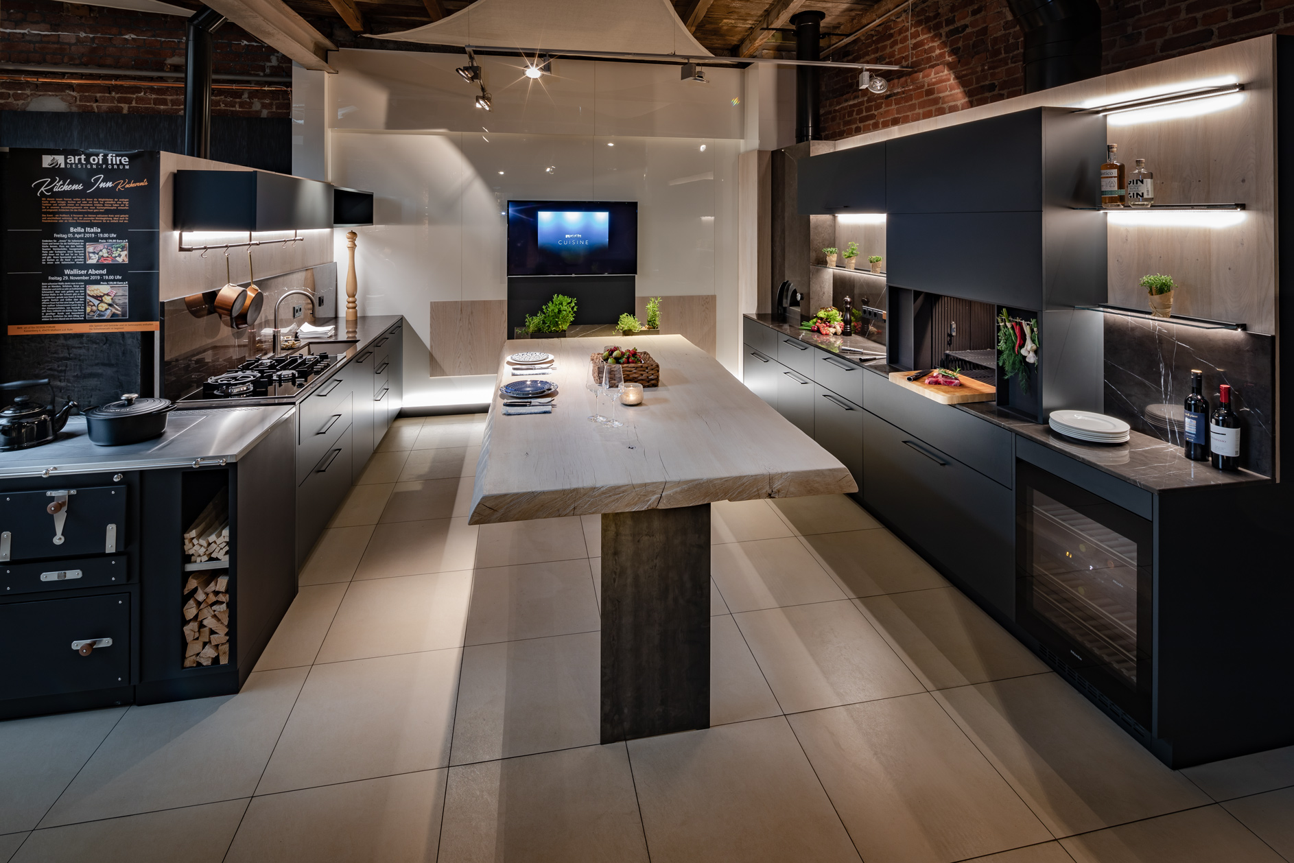 Moderne offene Küche mit Holzofen, Kücheninsel aus Massivholz, dunklen Fronten und stilvoller Beleuchtung in Loft-Optik.